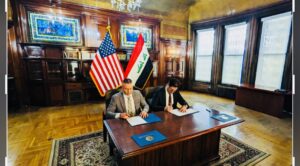 Special Agent Jake Archer, left, a member of the FBI's Art Crime Team, and Salwan Sinjaree, chargé d'affaires at the Embassy of the Republic of Iraq, sign documents marking the return of a stolen artifact on March 8, 2023.